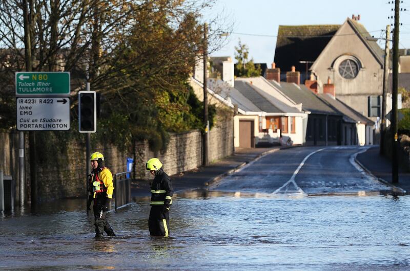 Members of the fire service walk through flood water in Mountmellick, Co Laois. Photograph: Brian Lawless/PA Wire