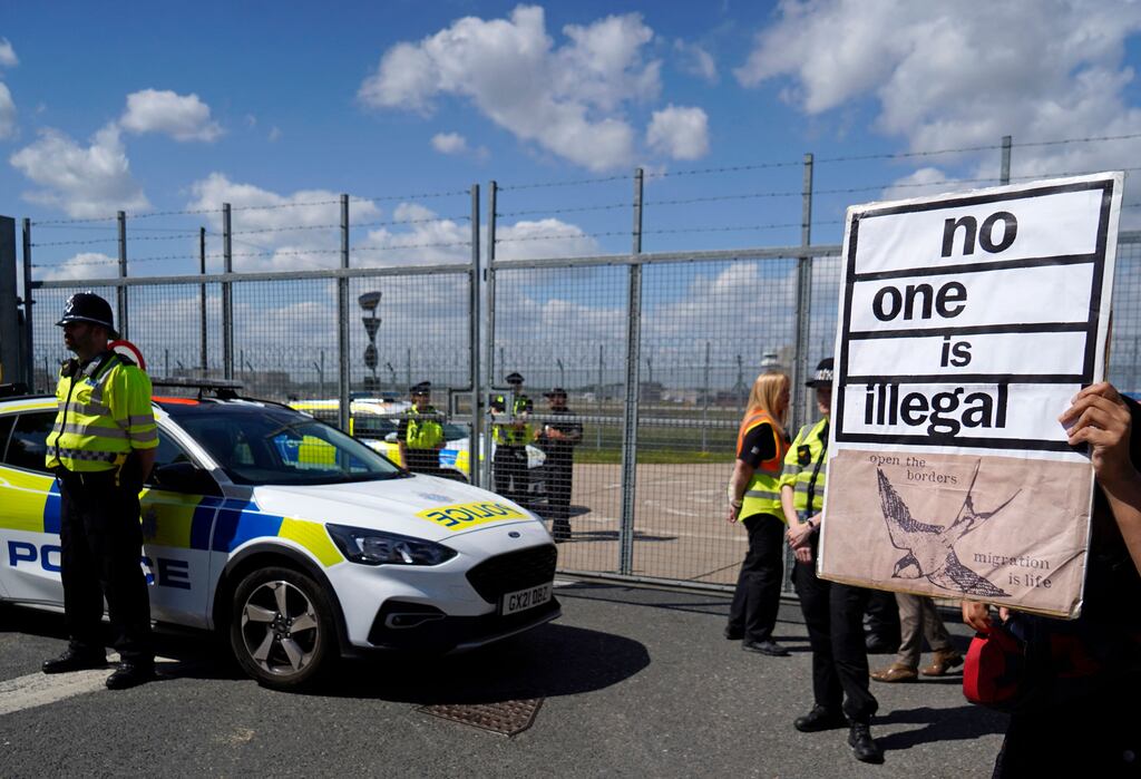 A protester holds up a sign in front of police officers during a demonstration against the UK government's intention to deport asylum seekers to Rwanda. UK policies are thought to be behind a jump in the number of asylum applications in the State. Photograph: Niklas Halle'n/AFP via Getty Images