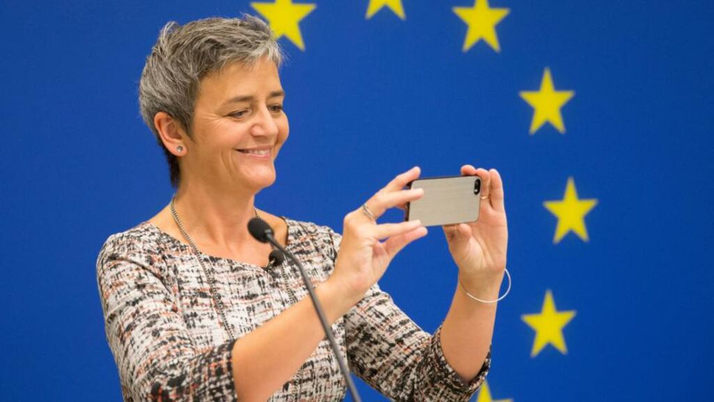 European commissioner for competition Margrethe Vestager uses an Apple iPhone to take a picture of the room from the podium as her news conference begins in Washington on Monday. Photograph: Michael Reynolds/EPA