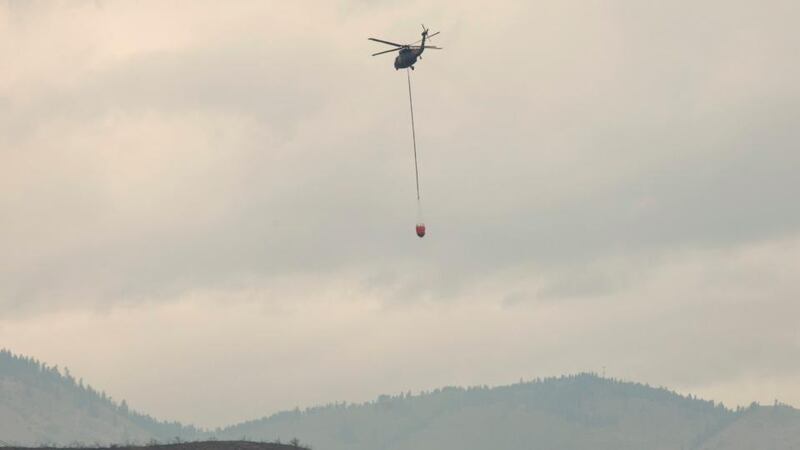 A helicopter carrying water flies toward the Carlton Complex Fire near Methow, Washington. Photograph: David Ryder/Reuters.