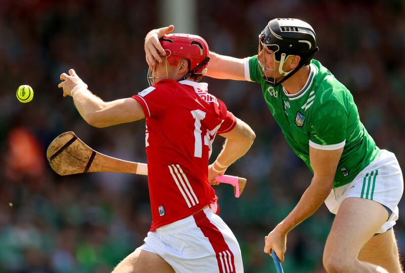 Cork’s Alan Connolly has his helmet tugged by Limerick's Diarmaid Byrnes. Photograph: James Crombie/Inpho