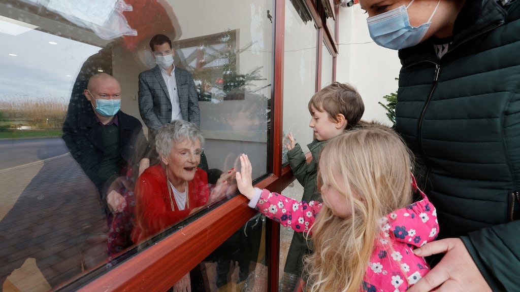 Stella Lonergan (83) from Portmarnock gets a Christmas visit from her son Rory and a window visit from her grandchildren Tess (4) and Ben (8) and daughter-in-law Laura Saunders at the Talbot Lodge nursing home in Malahide. Photograph: Alan Betson