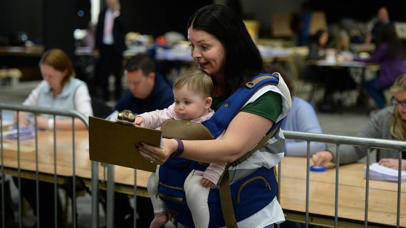 Vivienne Knight Hughes, from Balbriggan, keeping tally with baby Méabh Hughes at the Dublin county referendum count centre in Citywest, Dublin. Photograph: Dara Mac Dónaill/The Irish Times
