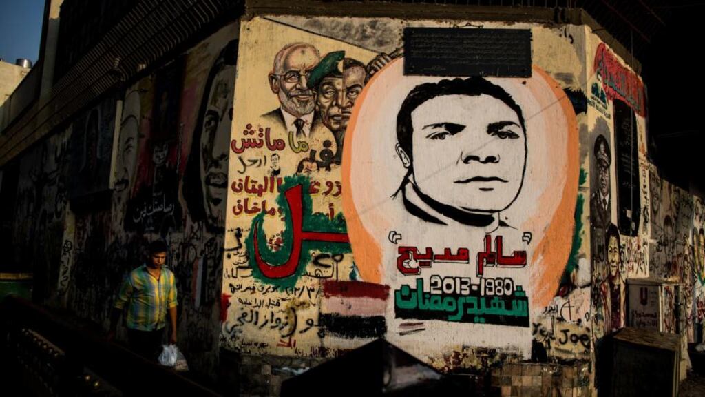 A portrait of Mohammed Badie, left, spiritual leader of the Muslim Brotherhood, behind the face of former president Hosni Mubarak, in graffiti on the walls of Cairo’s Tahrir Square, on Tuesday. Photograph: Bryan Denton/The New York Times