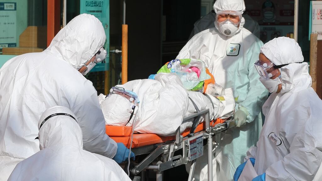 Medical workers wearing protective gear transfer a suspected coronavirus patient in China.