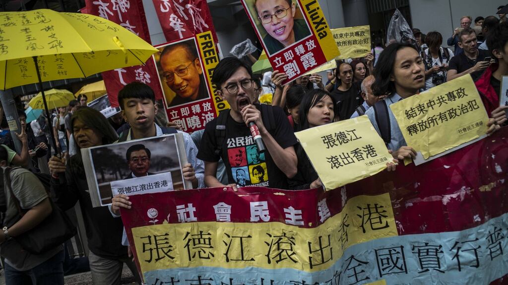Pro-democracy activists carry pictures of the visiting chairman of the standing committee of China’s National People’s Congress, Zhang Dejiang, along with detained Chinese Nobel Peace laureate Liu Xiaob and his wife Liu Xia, in Hong Kong on Wednesday. Photograph: Lam Yik Fei/Getty Images