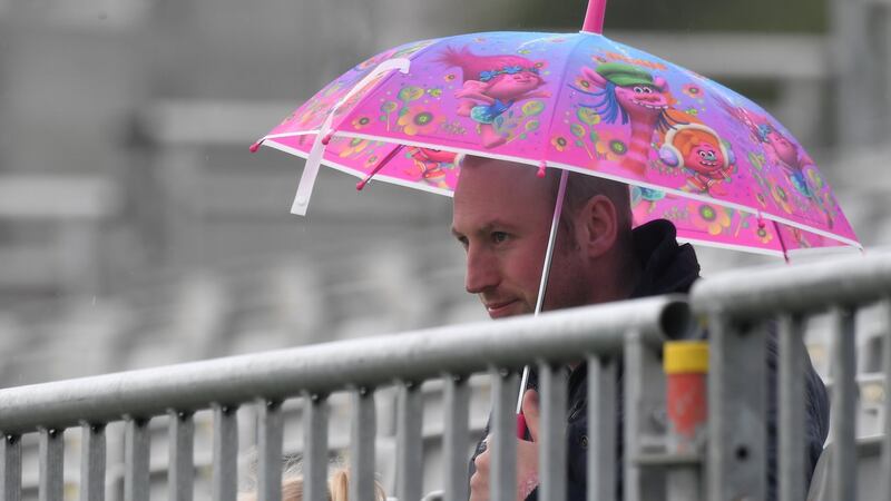 A spectator keeps dry on the first morning of the Test match between Ireland and Pakistan at Malahide. Photograph: Clodagh KIlcoyne/Reuters