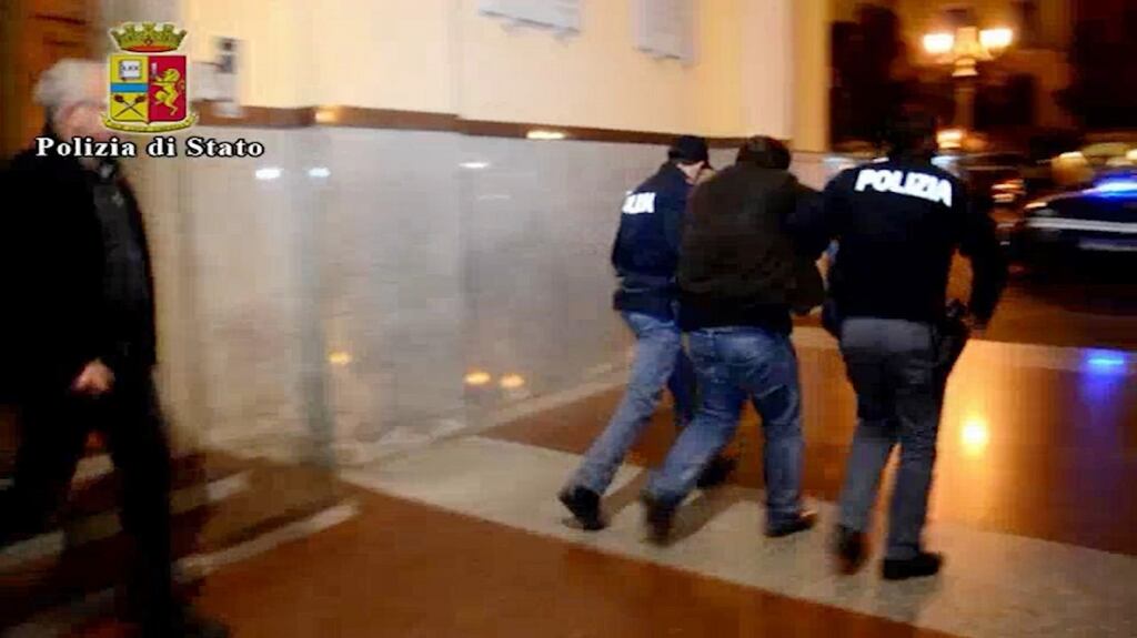 Italian Police escort a man, centre, to a police car in the southern city of Salerno, Italy. Police identified the man arrested as an Algerian wanted in Belgium for facilitating illegal migration linked to the recent terror attacks in Paris. Photograph: AP