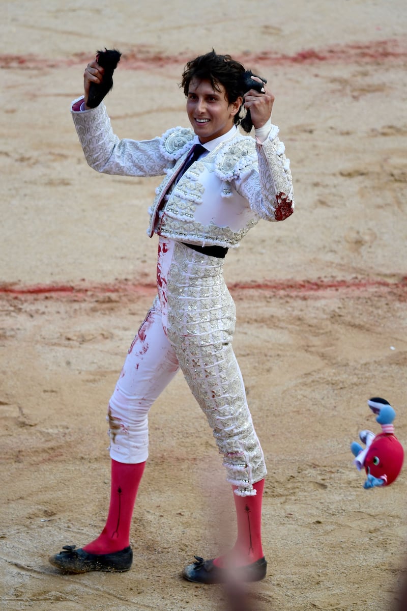 Bullfighter Andres Roca Rey celebrates by holding the cut-off ears of a Nunez del Cuvillo fighting bull during a bullfight of the San Fermin festival in Pamplona, northern Spain. Photograph: Ander Gillenea/AFP via Getty Images