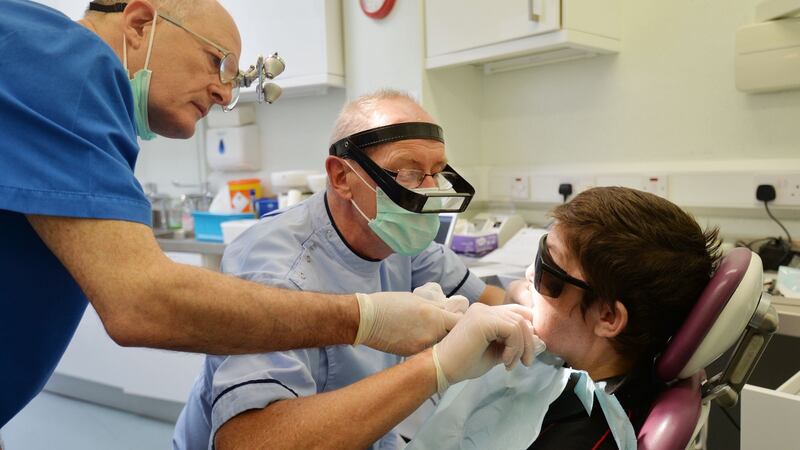 Dentists Jim Griffin (in light blue) and Brendan Fanning at their clinic in the Capuchin Day Centre for people who are homeless and don’t usually have access to dental care experts. Photograph: Alan Betson/The Irish Times