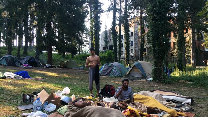 Migrants wake up in a field outside a derelict dormitory in Bihac, northwest Bosnia, which is now home to about 1,000 people. Photograph: Daniel McLaughlin