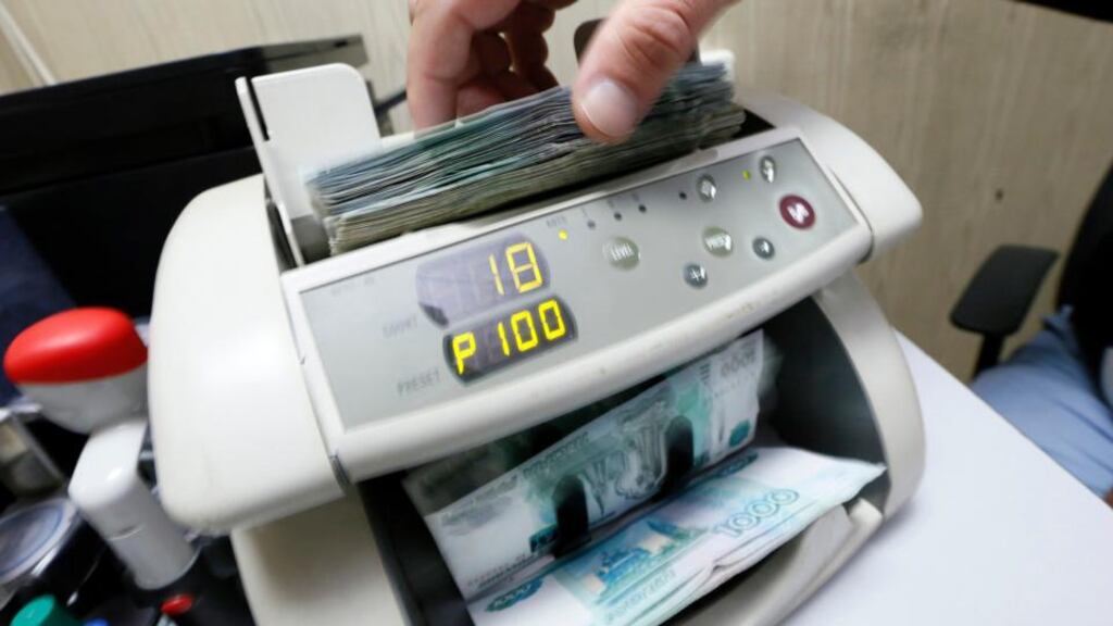 The Russian currency is down some 40 per cent against the dollar this year.An employee uses a machine while counting Russian ruble banknotes at a private company’s office in Krasnoyarsk, Siberia. Photograph: Ilya Naymushin/Reuters