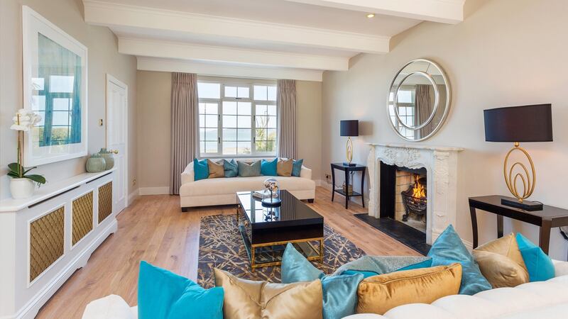 A long drawingroom on the left of the front hall with windows overlooking the sea has a marble fireplace, a painted beamed ceiling and an oak floor