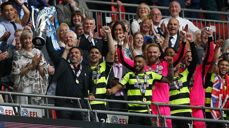 Huddersfield Town manager David Wagner and players celebrate with the trophy. Photograph: Reuters