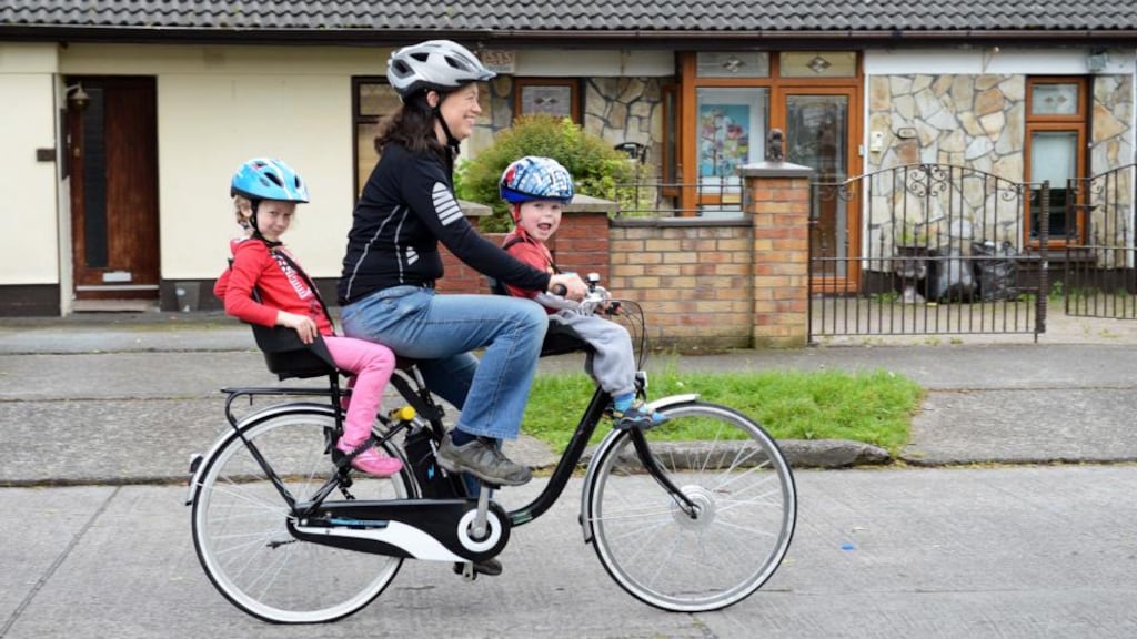Cliona Brophy on her e-bike with her children Bobby (3) and Alice (5), in Clondalkin, Dublin. Photograph: Eric Luke