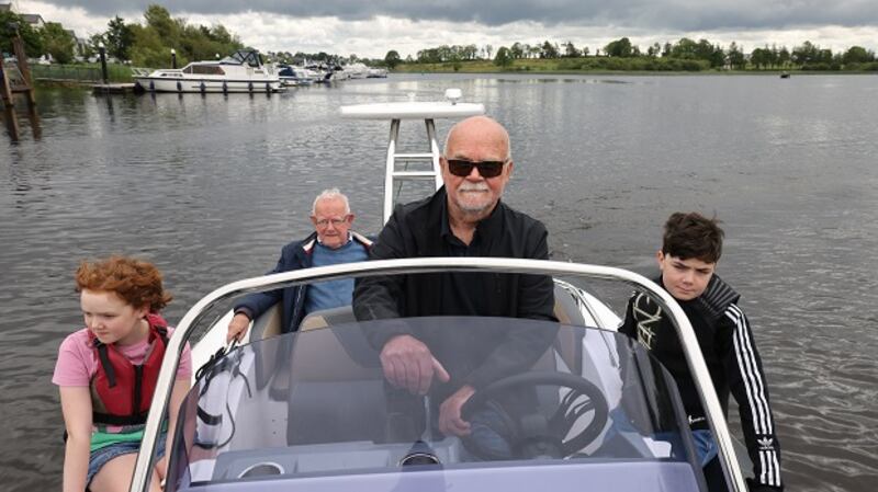 John Dunne driving his boat with his father Angus and his grandchildren Matilda and Felix Stanley, in Carrick-on-Shannon, Co. Leitrim. Photograph: Dara Mac Dónaill