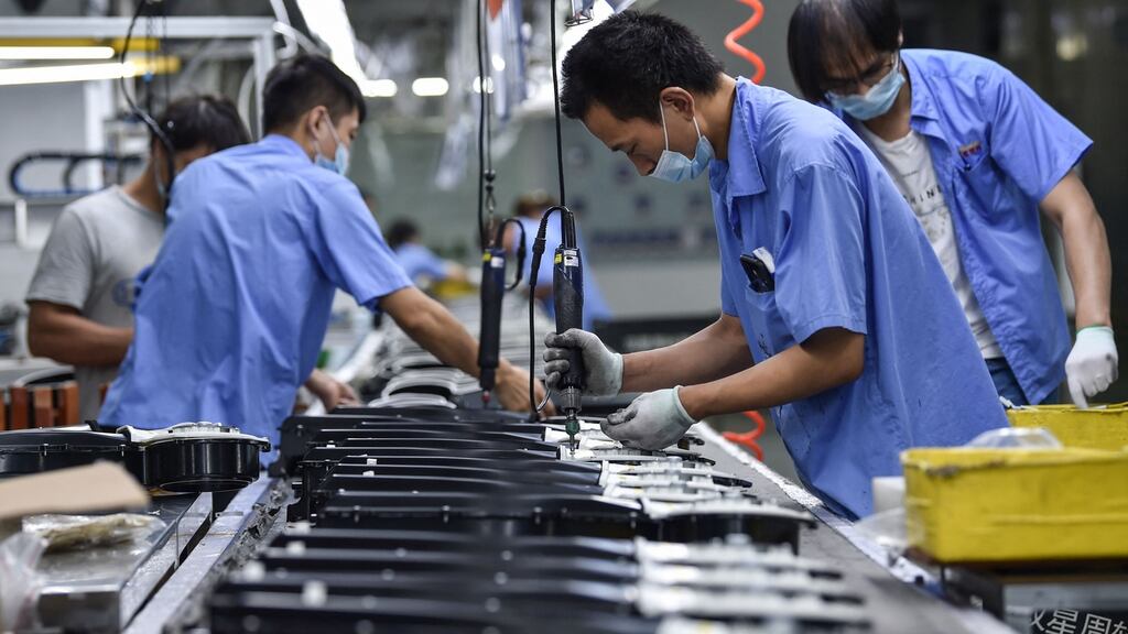 This photo taken on August 16, 2021 shows workers producing washing machine parts at a factory in Nanjing, in China’s eastern Jiangsu province. Photo by STR/AFP via Getty Images)