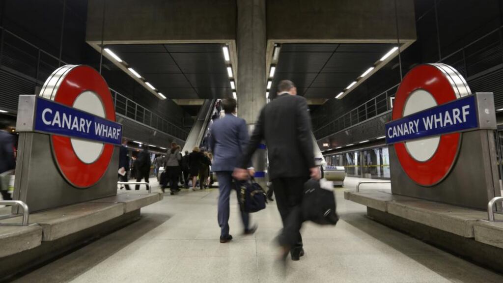 Commuters walk towards escalators after disembarking from a London Underground tube train at Canary Wharf station. Photo: Bloomberg