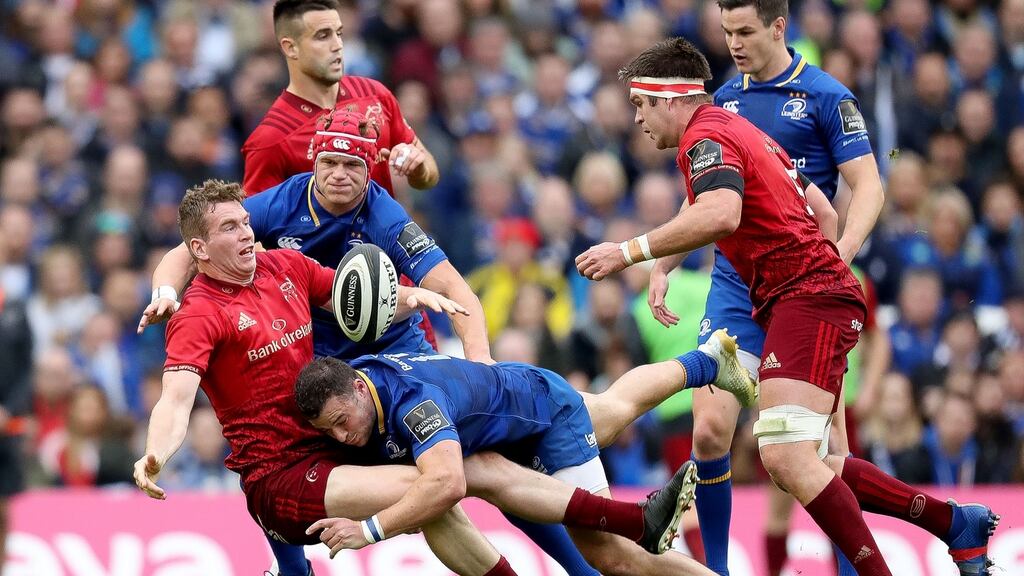 Munster’s Chris Farrell offloads as he is tackled by Leinster ’s Josh van der Flier and Robbie Henshaw at the Aviva Stadium. Photograph: Billy Stickland/Inpho