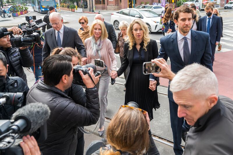 Theranos founder and chief executive Elizabeth Holmes, centre, walks into federal court with her partner Billy Evans, right, and her parents in San Jose, California (Nic Coury/AP)