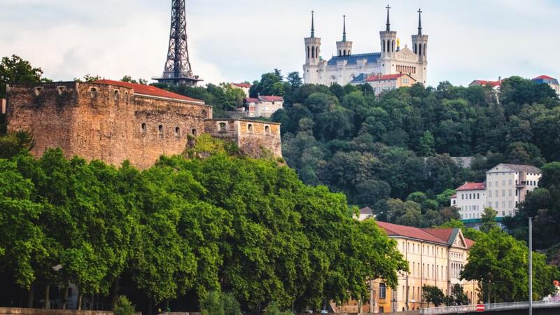 Fourvière hill with Basilica of Notre-Dame de Fourvière and communication tower in Lyon, as seen from Saone river.