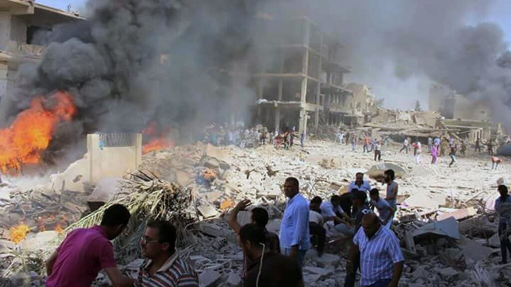 In this photo released by the Syrian official news agency SANA, Syrians gather at the scene where twin bombings struck Kurdish town of Qamishli, Syria. Photograph: SANA via AP