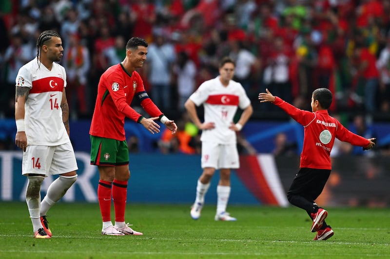 Portugal's forward Cristiano Ronaldo greets a young pitch invader. Photograph: Patricia De Melo Moreira/AFP via Getty