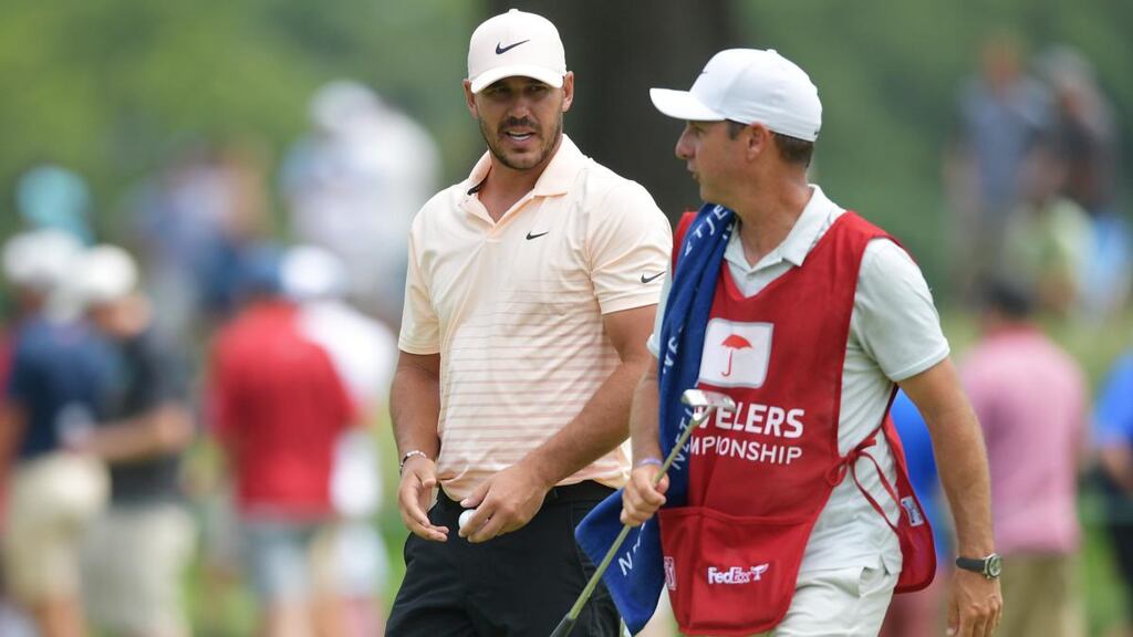 Brooks Koepka  talks with his caddie Ricky Elliott during the  Travelers Championship at TPC River Highlands in Cromwell, Connecticut back in June. Photograph:  Drew Hallowell/Getty Images