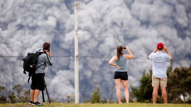 People watch as ash erupt from the Halemaumau crater near the community of Volcano during ongoing eruptions of the Kilauea Volcano in Hawaii, on Wednesday. Photograph:Terray Sylvester/Reuters