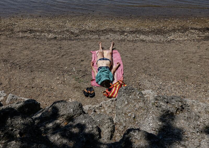 A woman sunbathes on the beach on the banks of the Bavarian lake Chiemsee in southern Germany amid this week's heatwave. Photograph: Michaela Stache/AFP via Getty Images