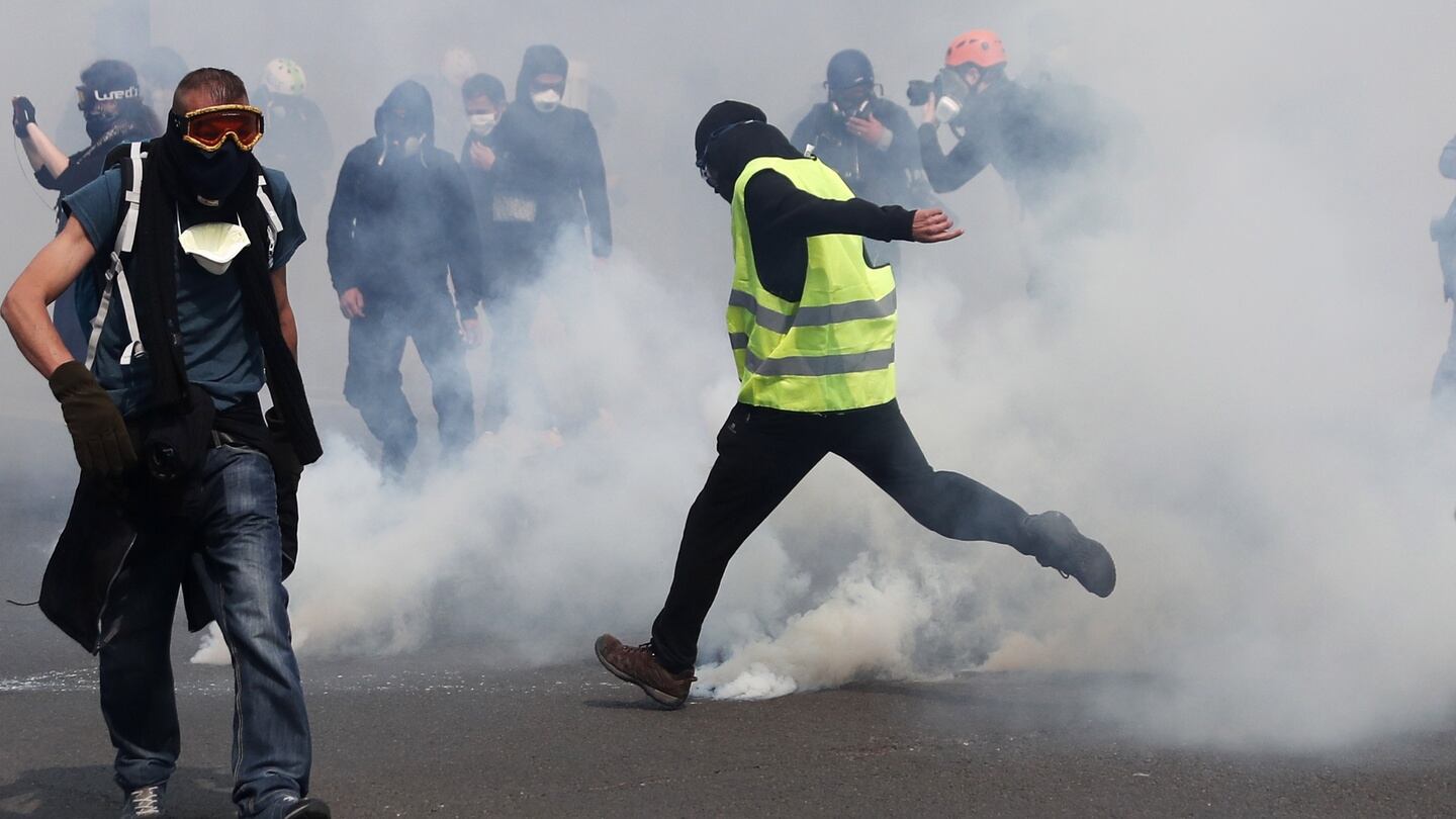 A Gilets Jaunes along with other masked protesters in Paris. Photography: Ian Langsdon