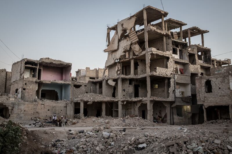 Men sit and chat in Tadamon, Damascus