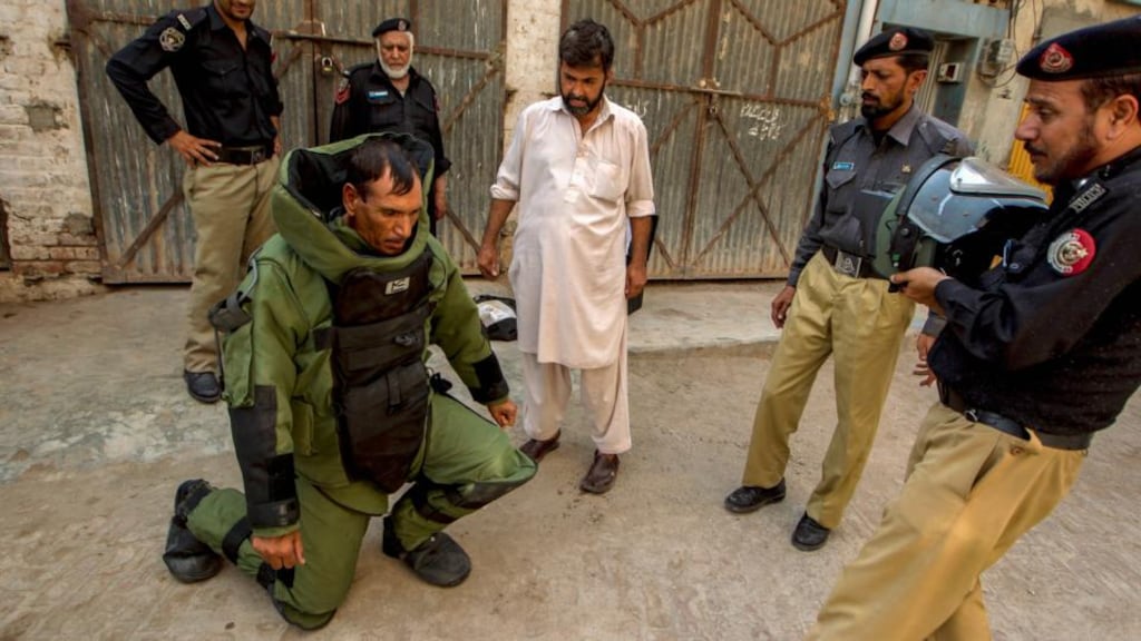 A technician from a Pakistani bomb disposal unit kneels down to rest, due to wearing his heavy protective suit, during a bomb search operation in Peshawar yesterday. Parts of Pakistan are frequently hit with bomb attacks. Photograph: Zohra Bensemra/Reuters