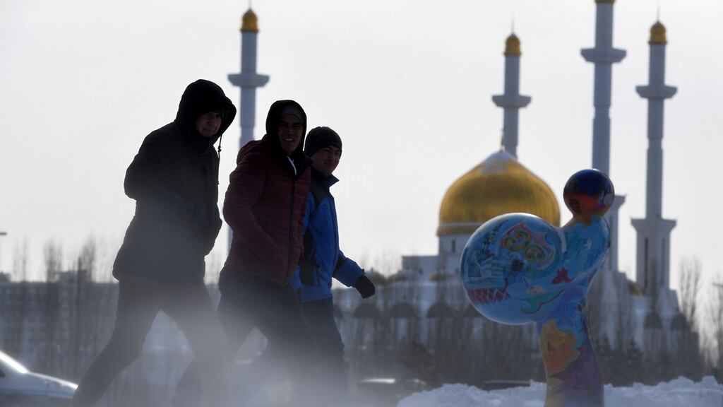 Men walk along a street, with Nur-Astana mosque seen in the background, in Astana the day before the talks begin. Photograph:  Kirill Kudryavtsevki/AFP/Getty Images