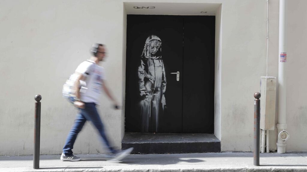 A man walks past an artwork by street artist Banksy in Paris on a side street to the Bataclan concert hall where a terrorist attack killed 90 people on November 13th, 2015. Photograph: Thomas Samson/AFP/Getty