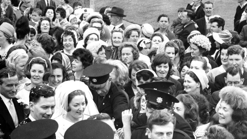 Gay Byrne and Kathleen Watkins being helped through a crowd of about 300 people who surrounded the couple when they left the Church of the Nativity, Saggart, Co Dublin, after their wedding in June 1964. Photograph: Gordon Standing