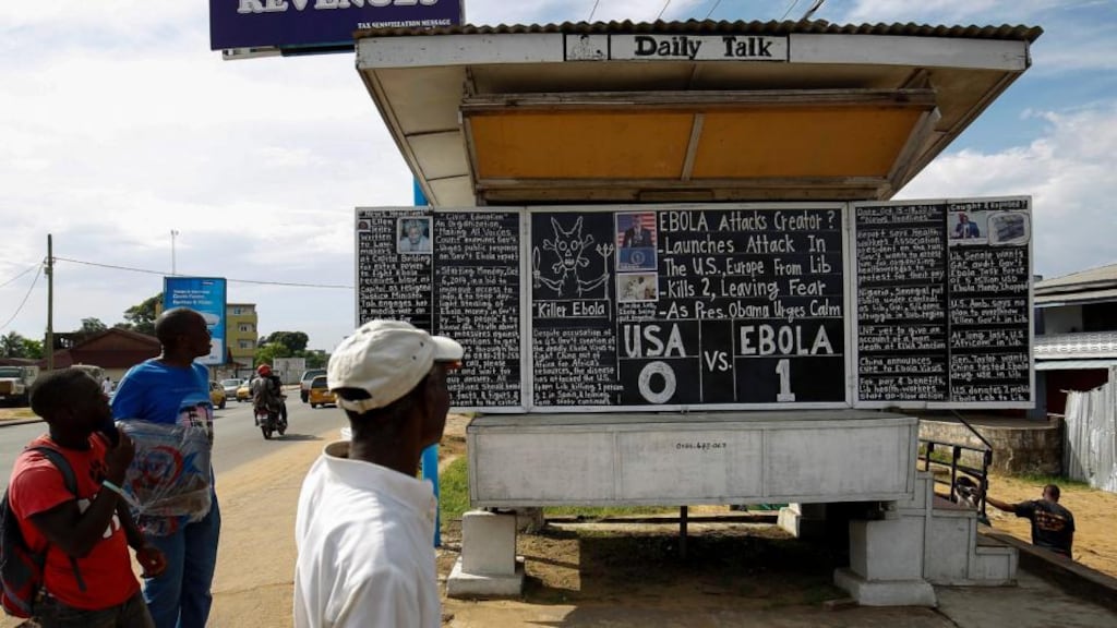 Liberians read the public Daily Talk chalkboard discussing the Ebola outbreak in the Sinkor district of Monrovia, Liberia. Photograph: Ahmed Jallanzo/EPA