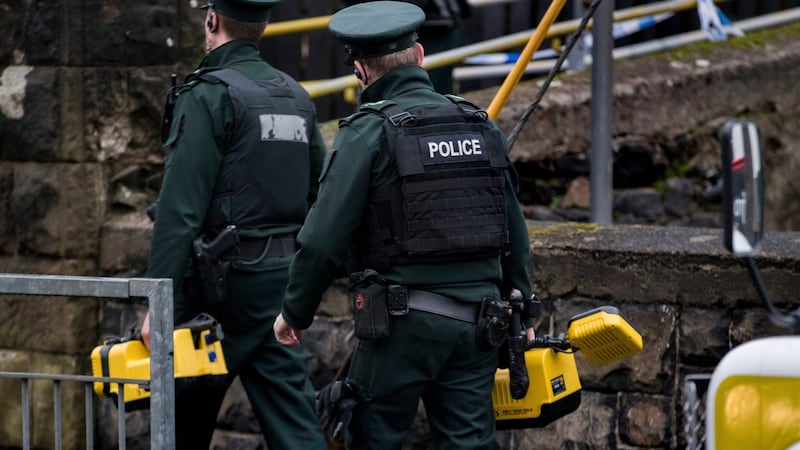 PSNI officers carry lights as they attend Dunmurry railway station in west Belfast, Northern Ireland, where a person died after being struck by a train. Photograph: Liam McBurney/PA Wire