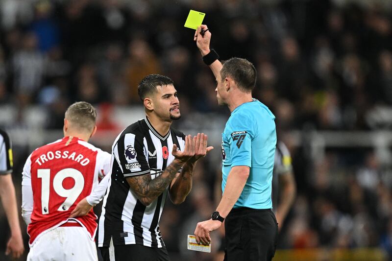 English referee Stuart Attwell shows a yellow card to Newcastle's Bruno Guimaraes during Newcastle's controversial victory over Arsenal at St James's Park. Photograph: Oli Scarff/Getty Images/AFP