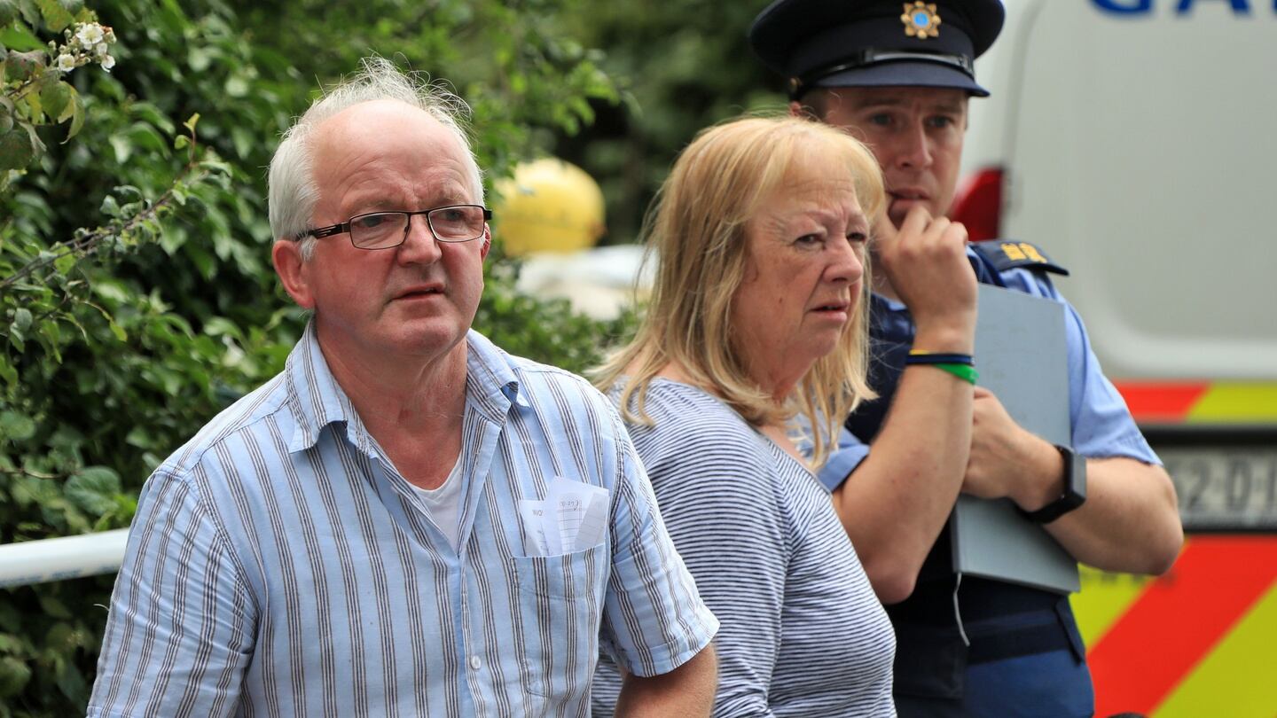Locals and a garda look on as human remains are removed after a house fire in Tully East, Co Kildare. Photograph: Colin Keegan/Collins Dublin