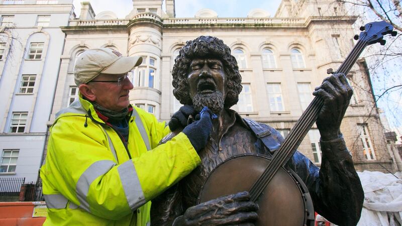 Sculptor John Coll who created the Luke Kelly Statue puts the finishing touches to the statue on South King Street, Dublin, to mark the 35th anniversary of the death of the musician. Photograph: Gareth Chaney/Collins