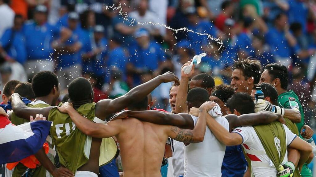 Costa Rica players   celebrate after winning their World Cup    match against Italy at the Arena Pernambuco in Recife and qualify from Group D. Photograph:  Yuri Kochetkov/EPA
