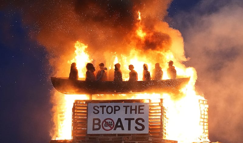 Effigies of migrants in a boat burn atop a bonfire at Moygashel, Co Tyrone. Photograph Niall Carson/PA