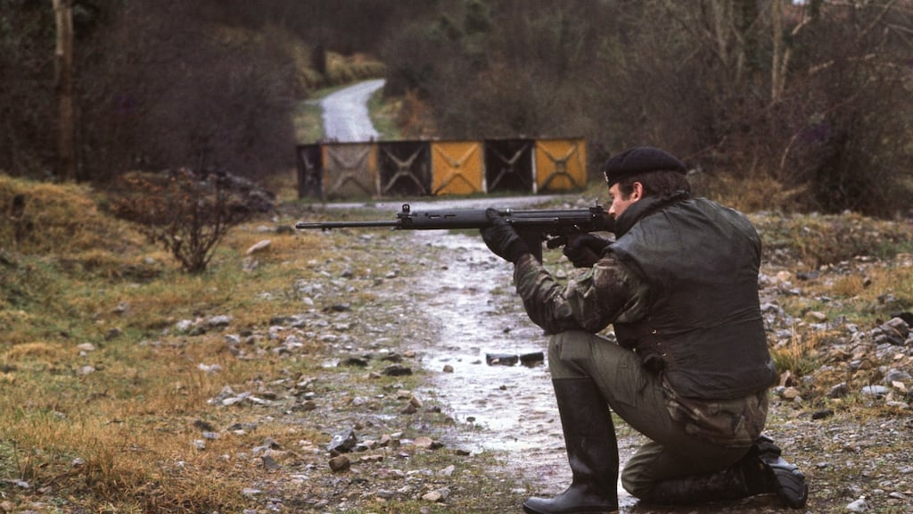 A British soldier patrols on a Border road in  Fermanagh,  blocked by a steel barrier, in  January 1978.  Photograph: Alex Bowie/Getty Images