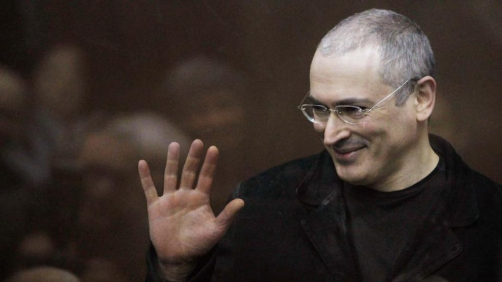 Jailed Russian former oil tycoon Mikhail Khodorkovsky waves as he stands in the defendants’ cage before the start of a court session in Moscow in this December 27th, 2010 file photograph. Photograph: Denis Sinyakov/Files/Reuters.