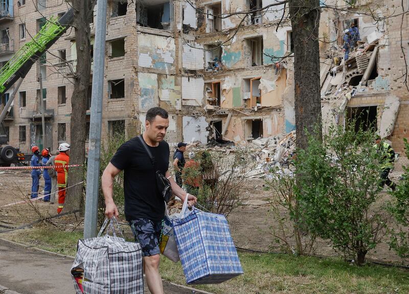 Local people carry their things from damaged flats at the site of a rocket strike on a five-storey residential building in Kyiv on Monday. Photograph: Sergey Dolzhenko/EPA
