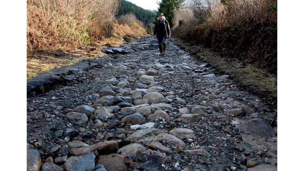Wicklow farmer Gerry Pender walks where the road to his house was before it was washed away in floods between Aughrim and Avoca. Many roads across the country are still closed or are badly damaged.