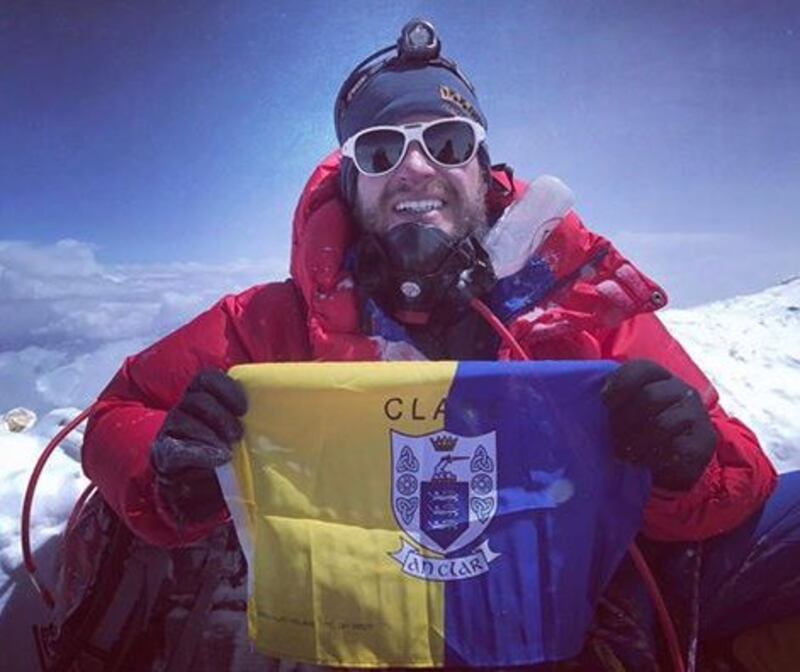 Irish man John Burke holds up a Clare flag after he reached the summit of Everest last week.