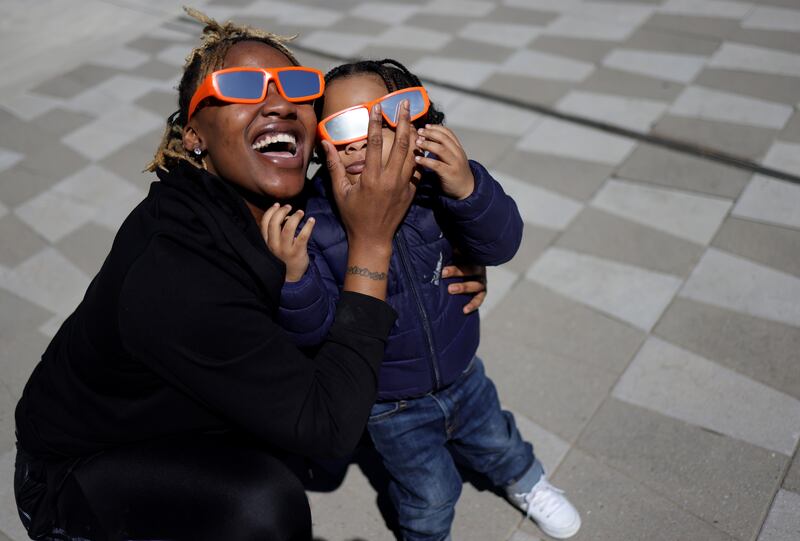 A woman and child take in the partial solar eclipse outside of the Fiserv Forum in Milwaukee, Wisconsin. Photograph: Kevin Dietsch/Getty Images