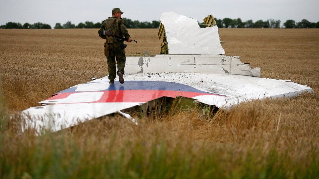 An armed pro-Russian separatist stands on part of the wreckage of the Malaysia Airlines Boeing 777 plane after it crashed near the settlement of Grabovo in the Donetsk region, July 17th, 2014. A Dutch investigation team are Wednesday announcing  the long-awaited results of an investigation with Australia, Malaysia, Belgium and Ukraine into the  downing of the flight. Photograph: Maxim Zmeyev/Reuters